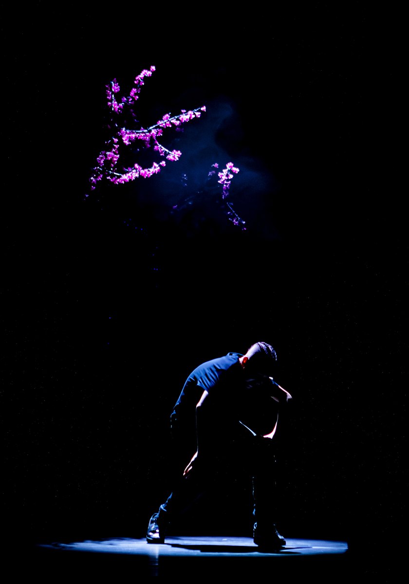 Danser in een smalle spotlight op een donker podium