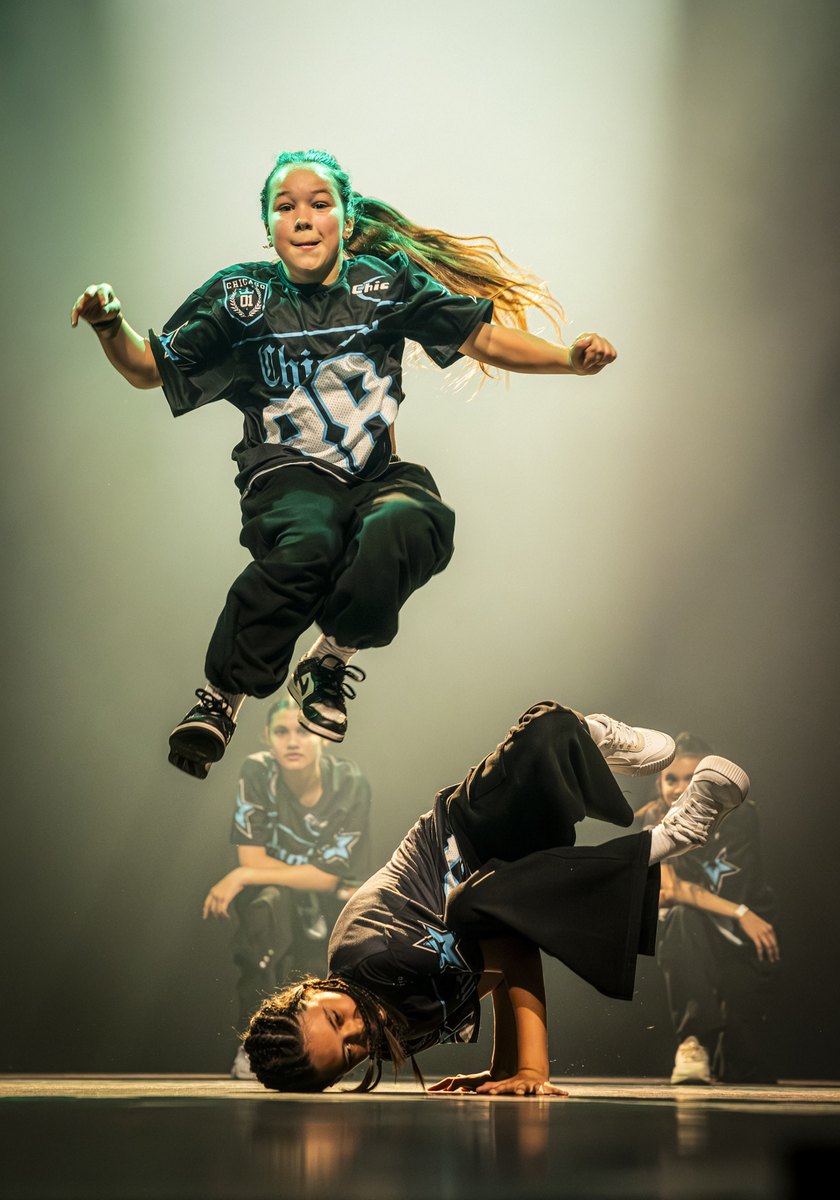 Danser springt hoog over een breakdancer heen