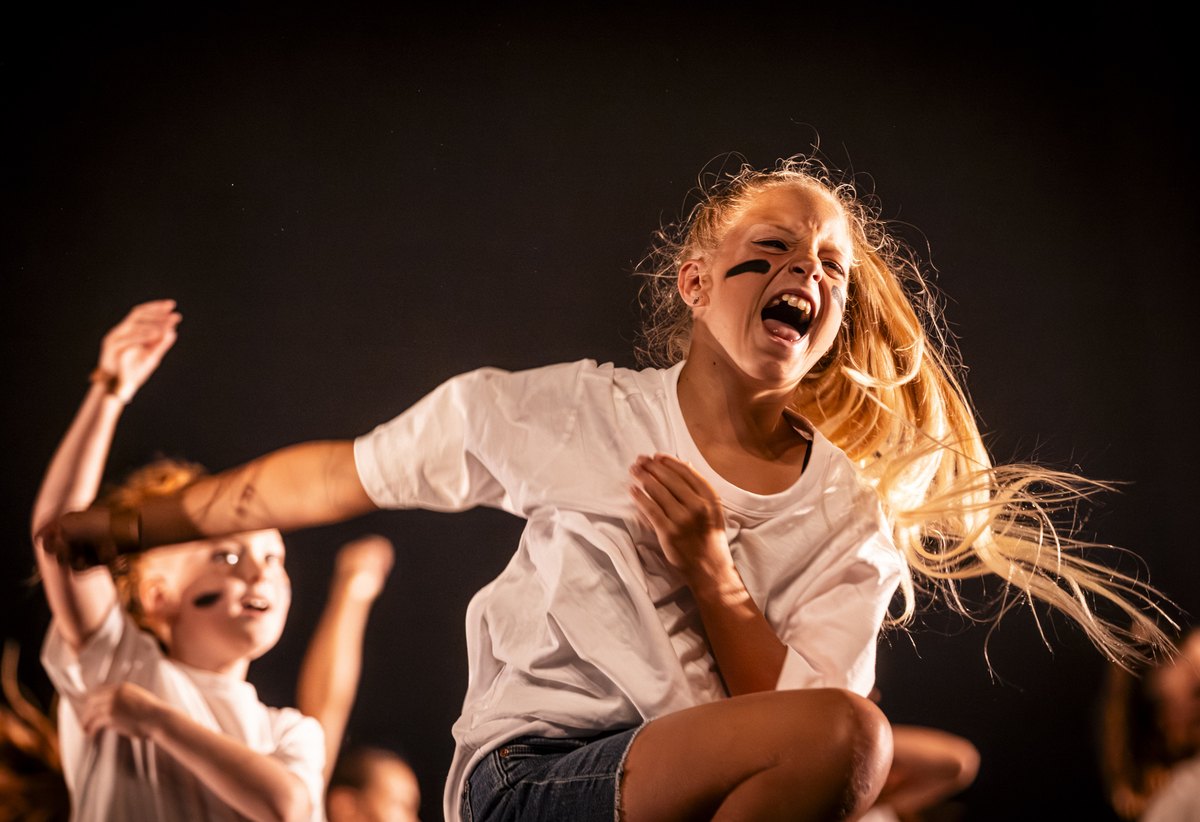 Jonge danseres vol energie in warm licht