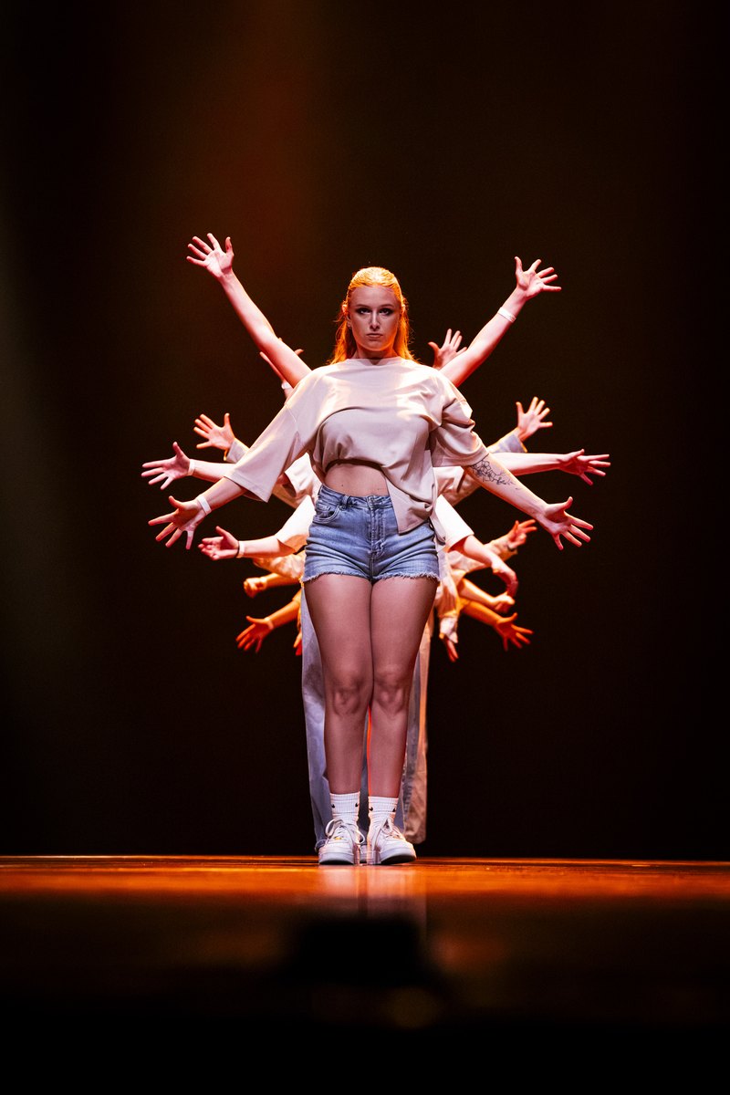 Danseres met veelarmig effect in oranje licht