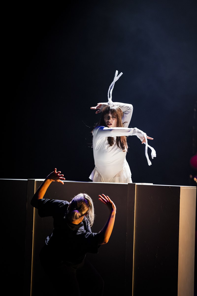 Twee dansers op en voor een podiumblok
